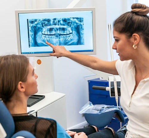 Bild Beratung Bild von einer Zahnärztin die einer Patientin, ein Röntgenbild erklärt.