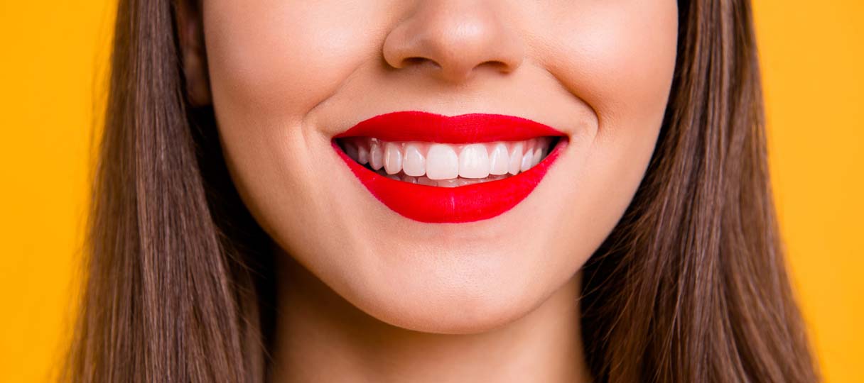 prophylaxe-kudamm1 Frau lächelt mit roten Lippenstift und sauberen weißen Zähnen