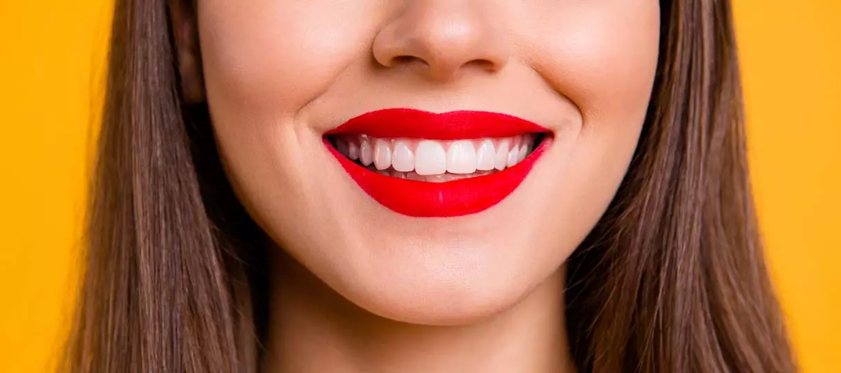 prophylaxe-kudamm1 Frau lächelt mit roten Lippenstift und sauberen weißen Zähnen